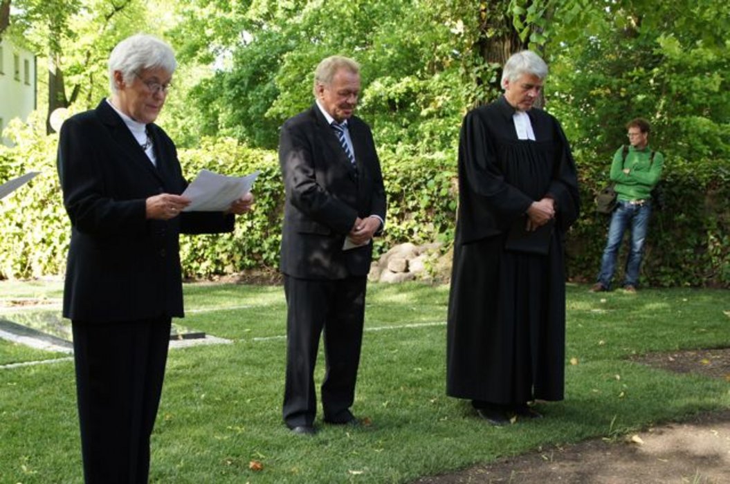 Heidemarie Grabow (Älteste im Gemeindekirchenrat), Bürgermeister Jürgen Henze und Pfarrer Matthias Scheufele an der Kriegsgräberstätte